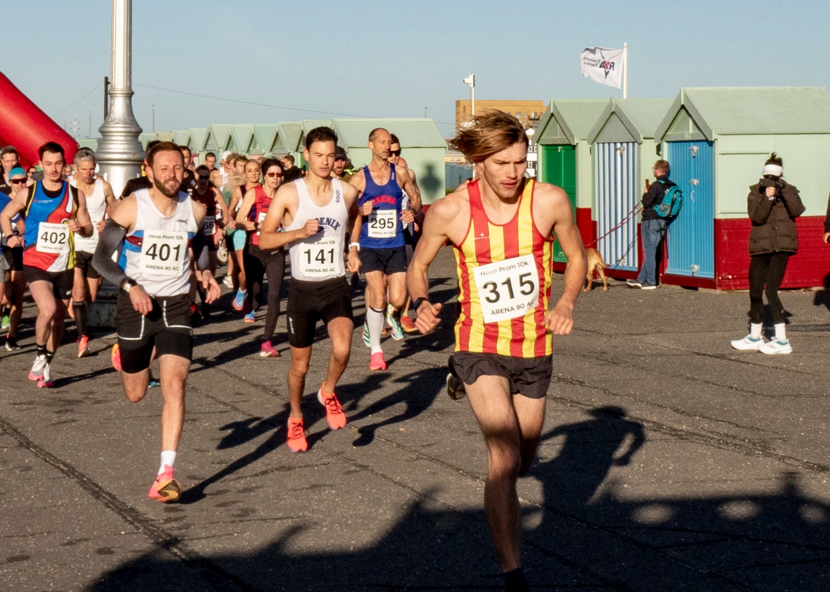Running past beach huts during Hove Prom 10K 2023